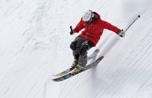Skier in red jacket skiing it down a steep ungroomed slope